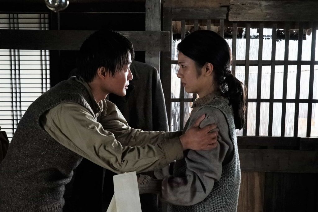 A man grabs a woman's shoulders in a scene from "Godzilla Minus One."